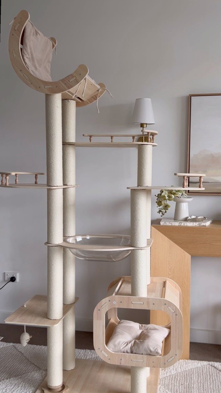 Modern cream and wood cat tree with platforms and a small house.