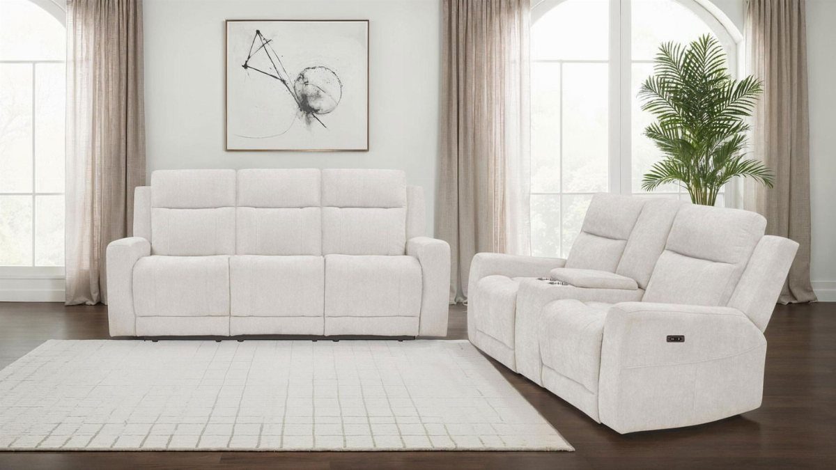 Two off-white fabric sofas arranged in a bright living room with a rug.
