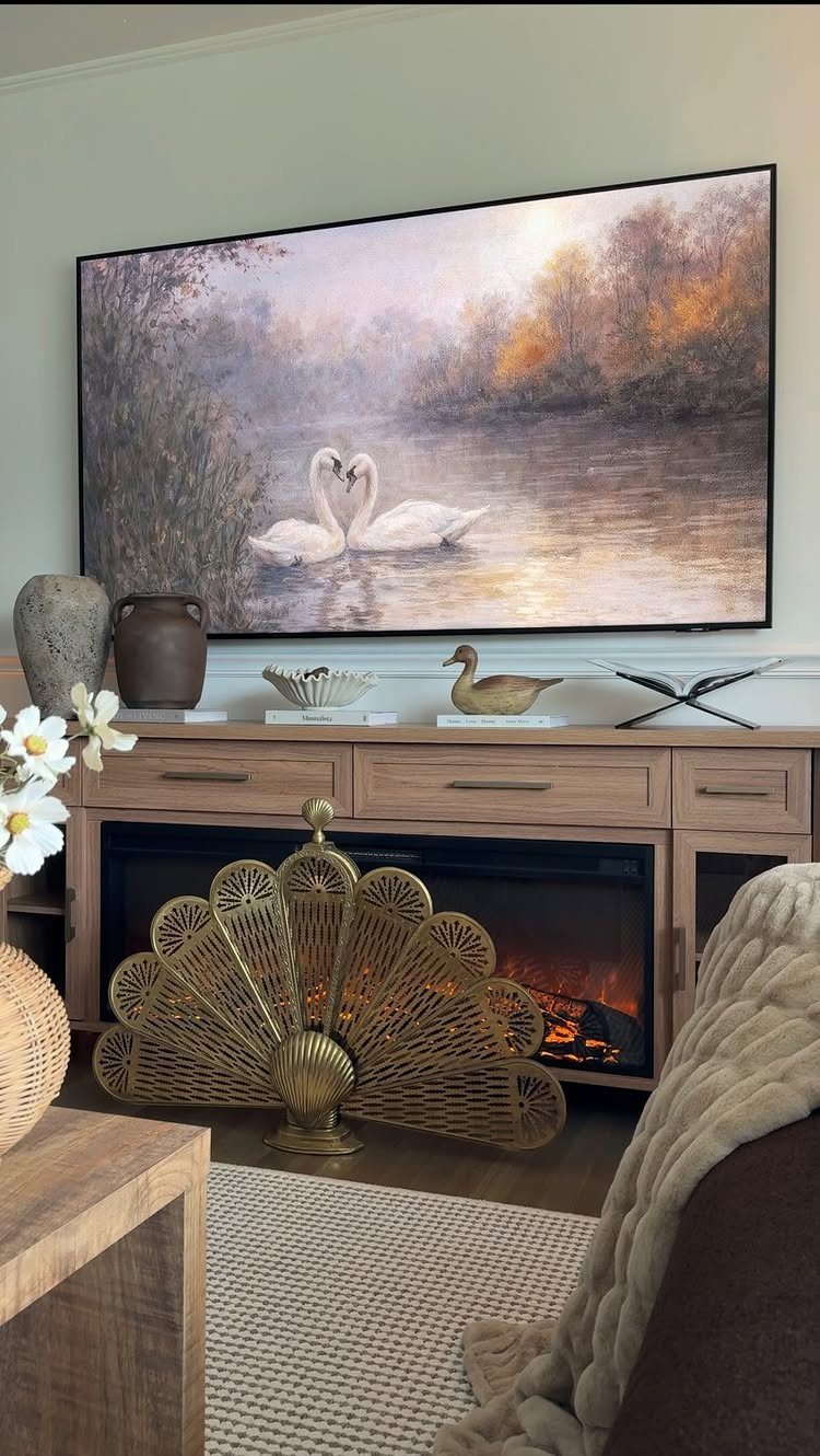 Gold peacock-shaped vintage fireplace screen in front of a burning fire and wooden mantel.