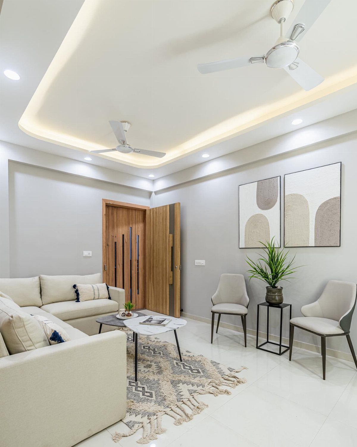 Modern living room with light grey walls, cream sofa, and white marble table.