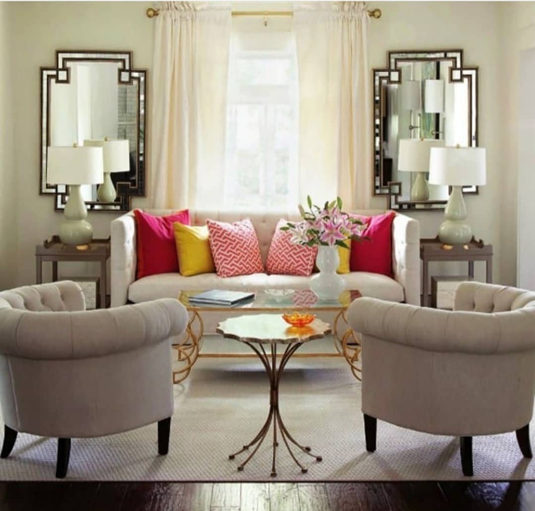 Symmetrical living room layout with a white sofa, matching side tables, and two armchairs.