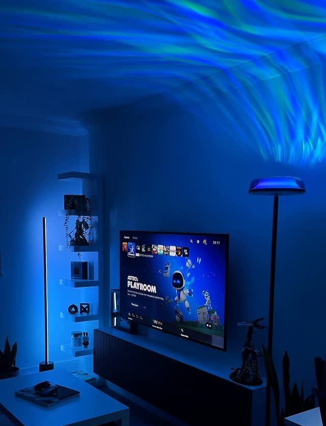 Living room with blue ambient lighting, a television, and a modern floor lamp.
