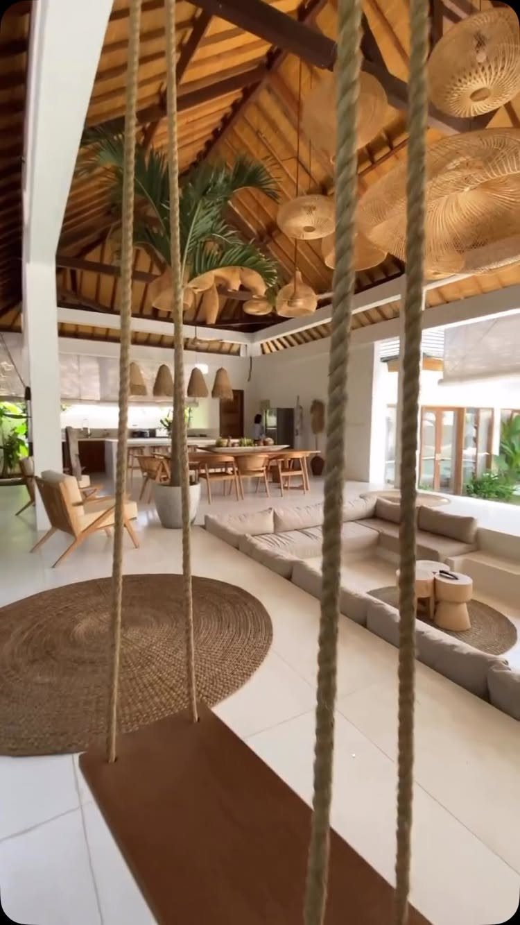 Woven rattan pendant lights hanging from a vaulted wooden ceiling in a bright living room.