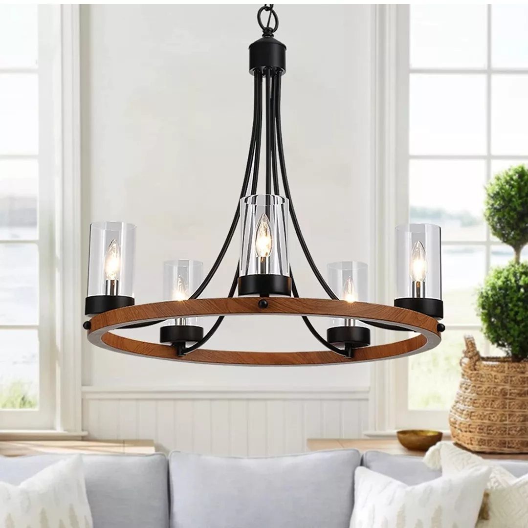 Wagon wheel chandelier with wooden frame and glass shades hanging in a bright room.