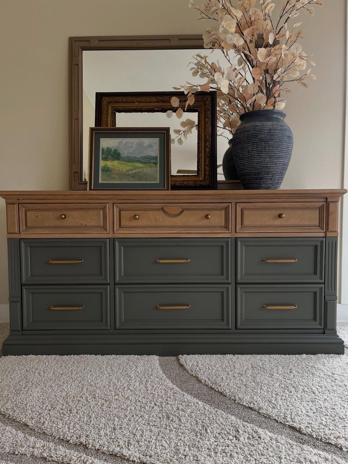 Dark grey painted dresser with natural wood top and decorative items on top