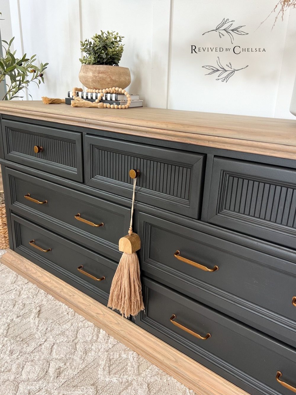 Dark grey painted dresser with natural wood top and gold hardware.