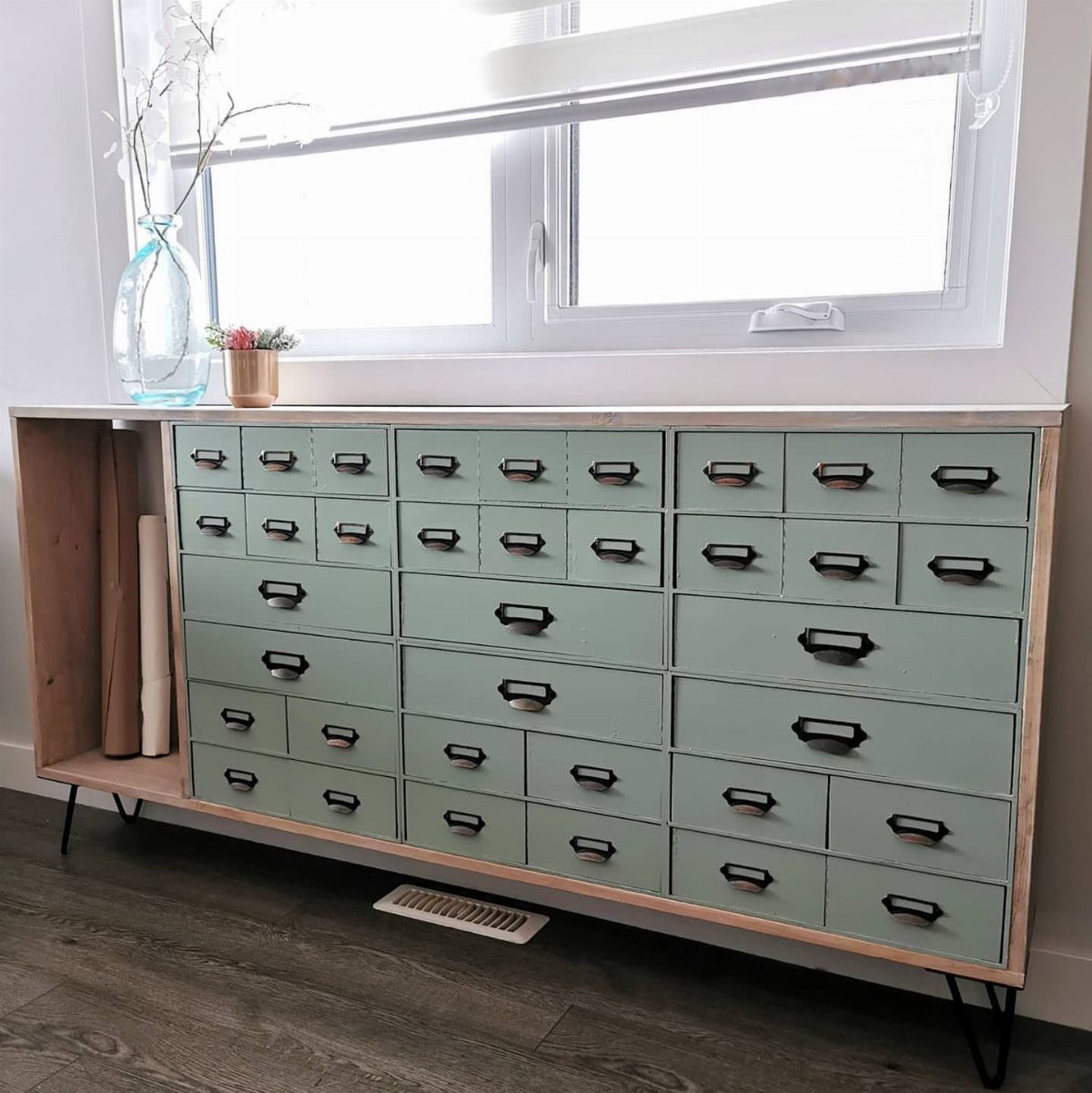 Sage green dresser with many small drawers styled as a DIY card catalog.