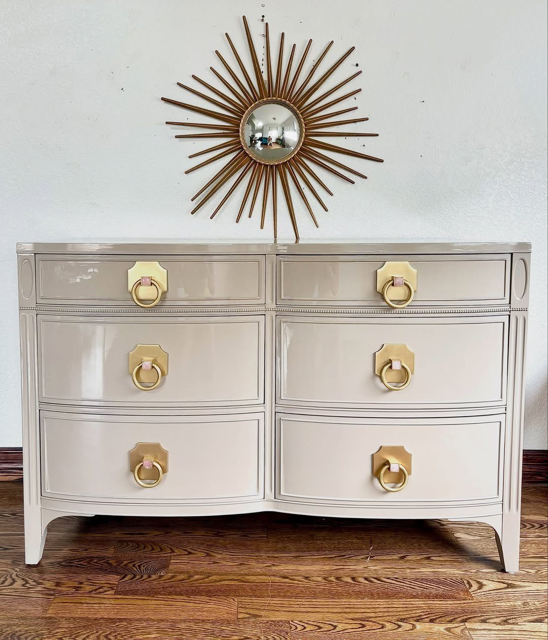 Cream vintage dresser with gold ring pulls under a gold sunburst mirror