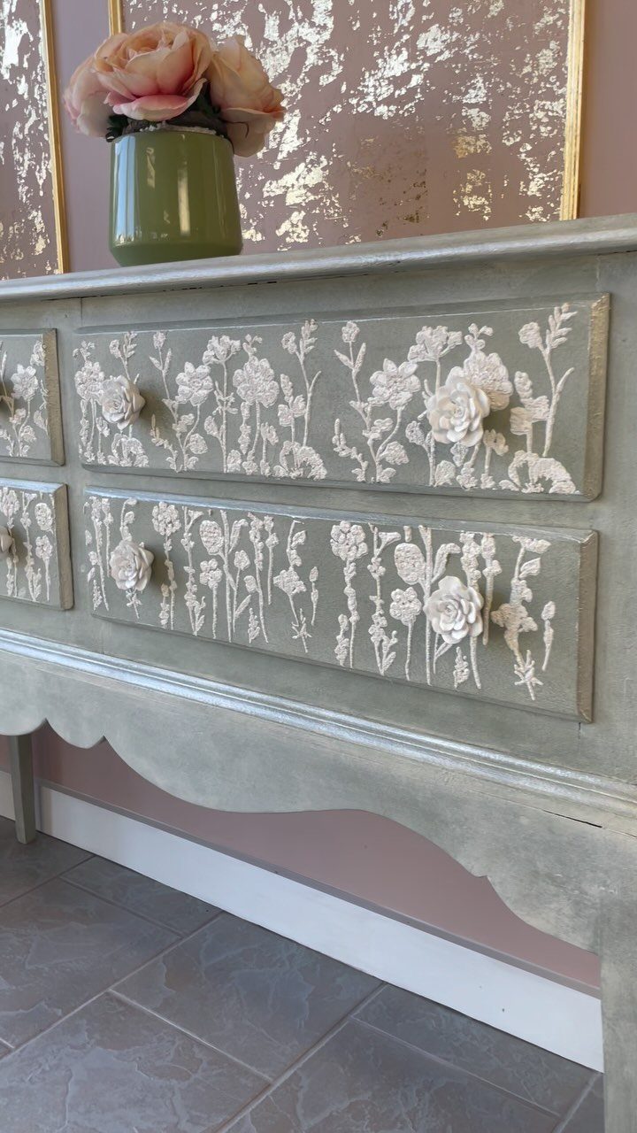 Grey dresser with raised white 3D floral textured paint on the drawer fronts.