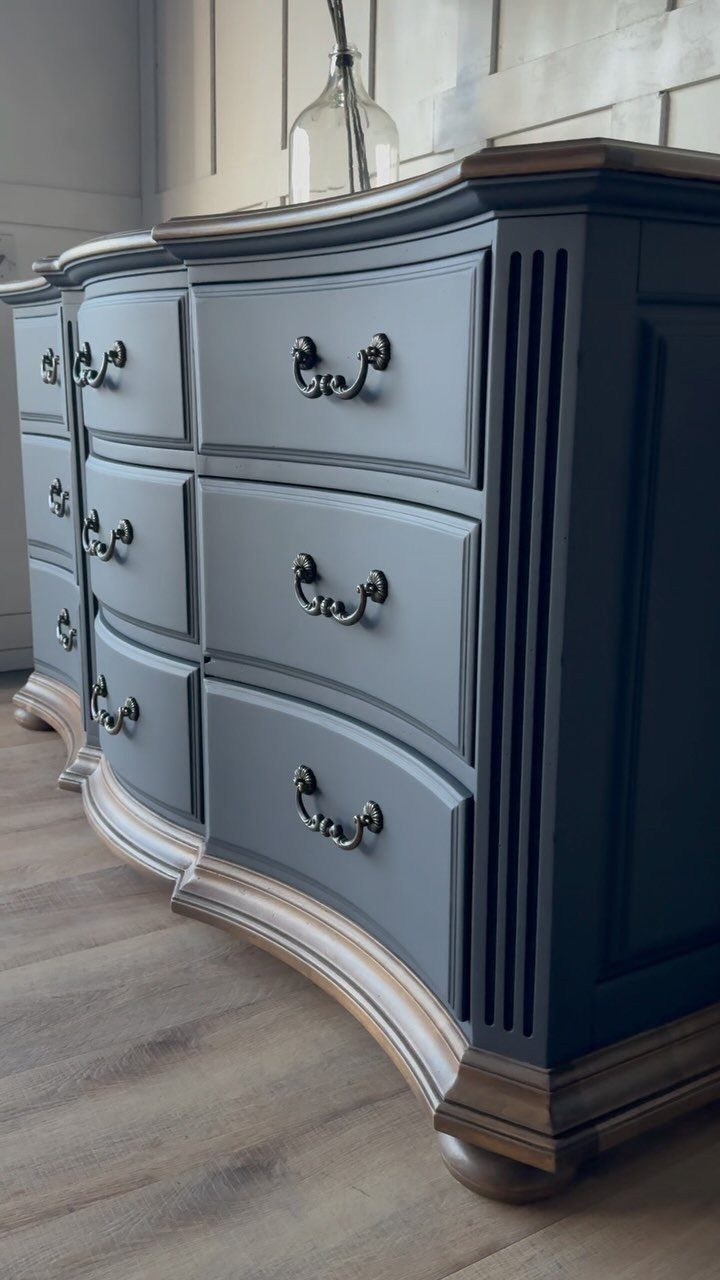 Deep charcoal grey painted dresser with ornate metal handles and natural wood trim.