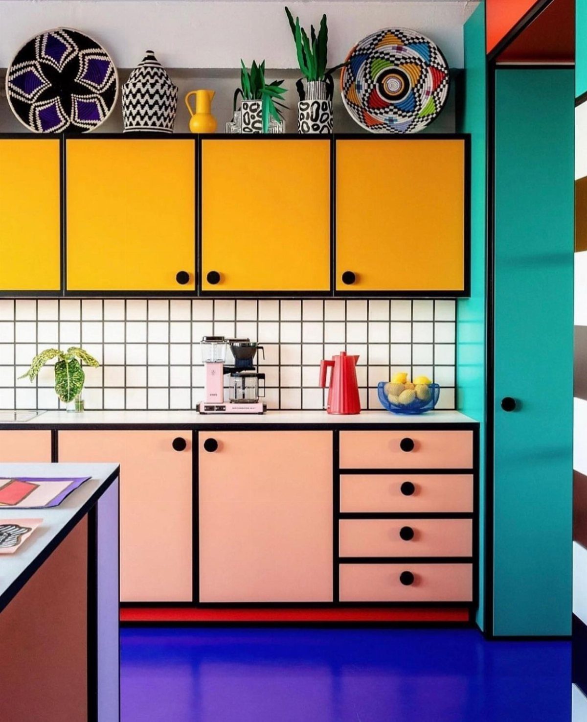 Colorful kitchen cabinets with bold black outlines and a purple floor.