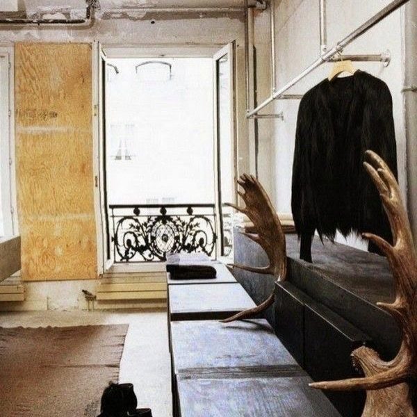 Concrete bench with large deer antlers in a minimalist, brutalist interior room