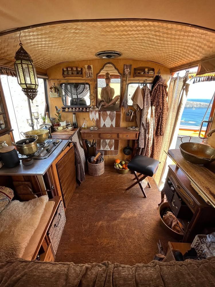 Bohemian RV interior with wooden furniture, woven ceiling, and eclectic decorative accents.