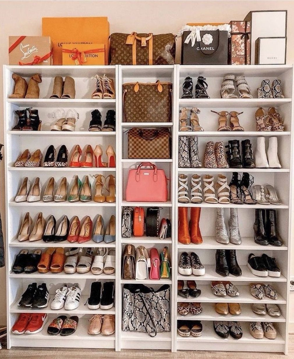 White bookcases used as shoe displays filled with luxury heels and designer handbags.