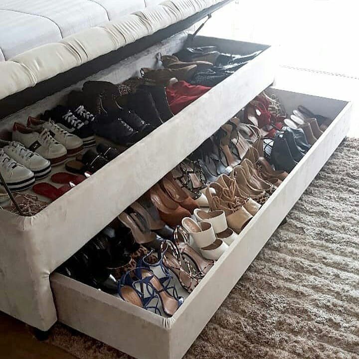 Under-bed storage drawers and a lift-up mattress filled with various women's shoes.