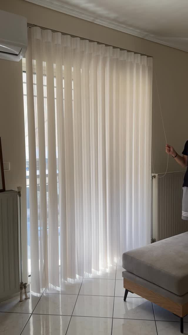 White sheer curtains covering a sliding glass door in a bright modern room.