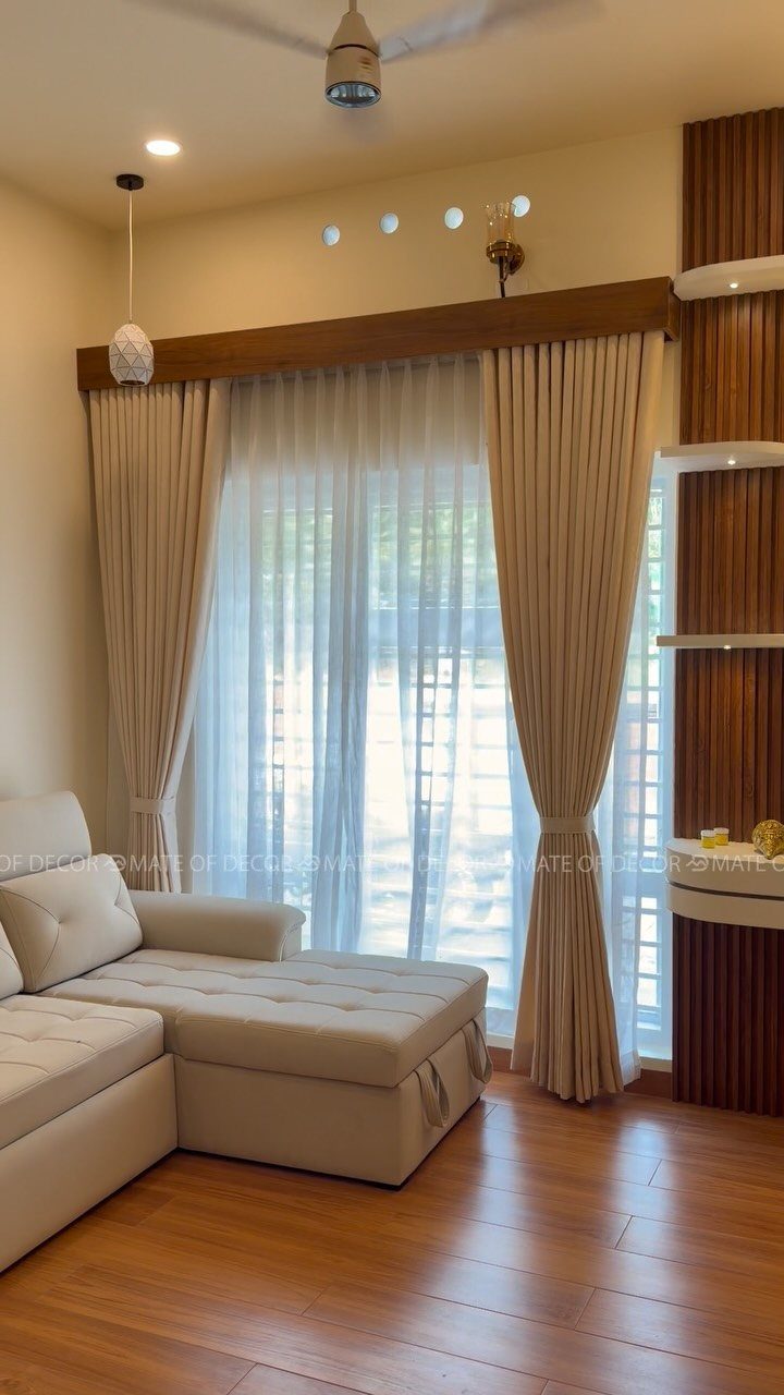 Beige blackout drapery paired with white sheer curtains in a modern living room.