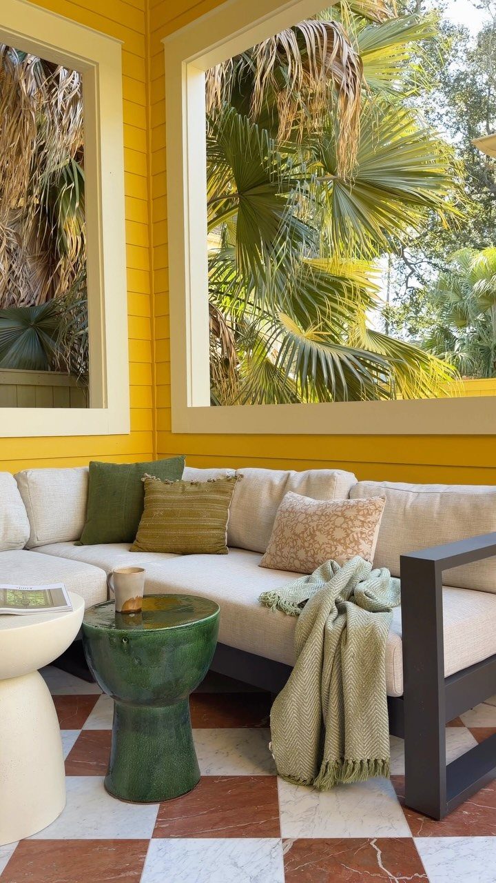 L-shaped sectional sofa with cream cushions on a yellow porch with checkered flooring