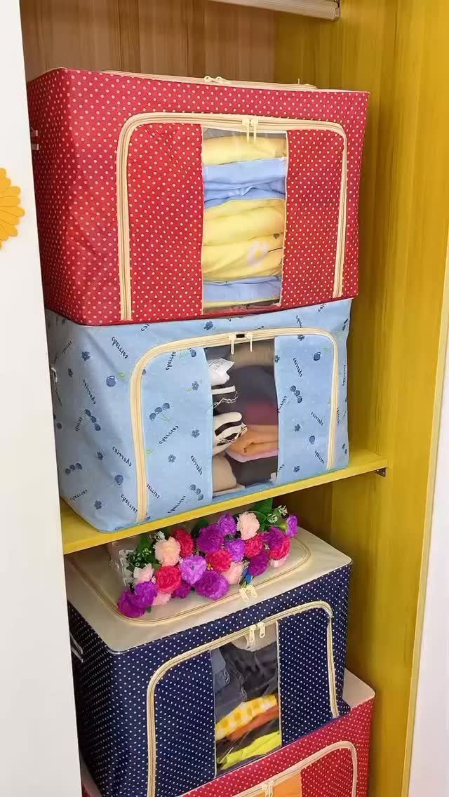 Fabric storage bins with clear windows containing folded clothes on a closet shelf