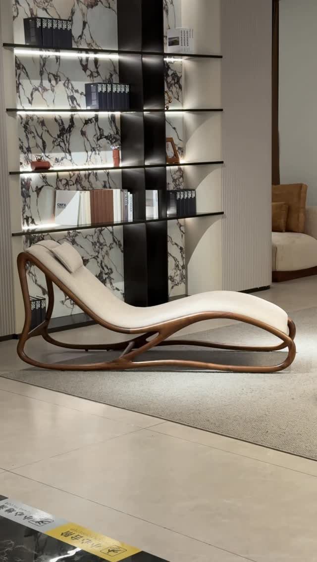 Curved chaise lounge with light fabric and wooden frame in a modern room