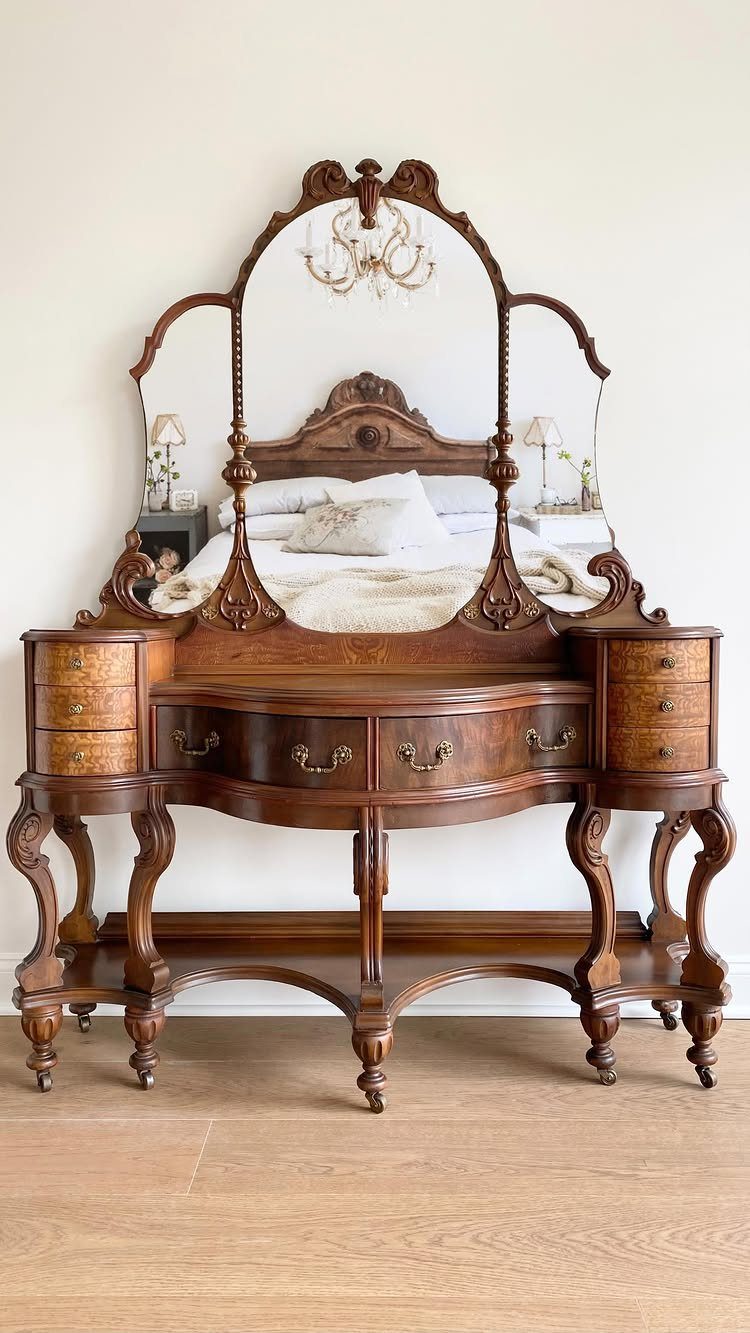 Ornate wooden dressing table with a large tri-fold mirror and curved legs.